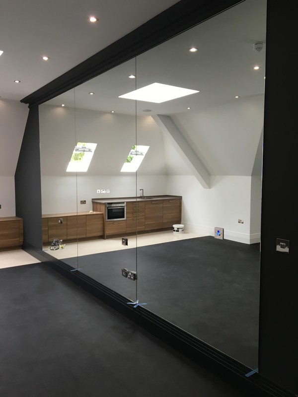 Frameless glass partition in loft conversion by Southall glaziers