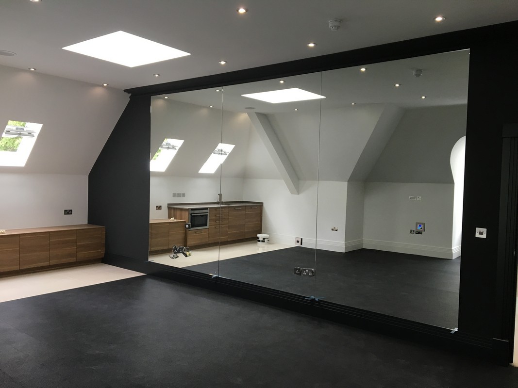 Frameless glass wall dividing loft conversion in Southall